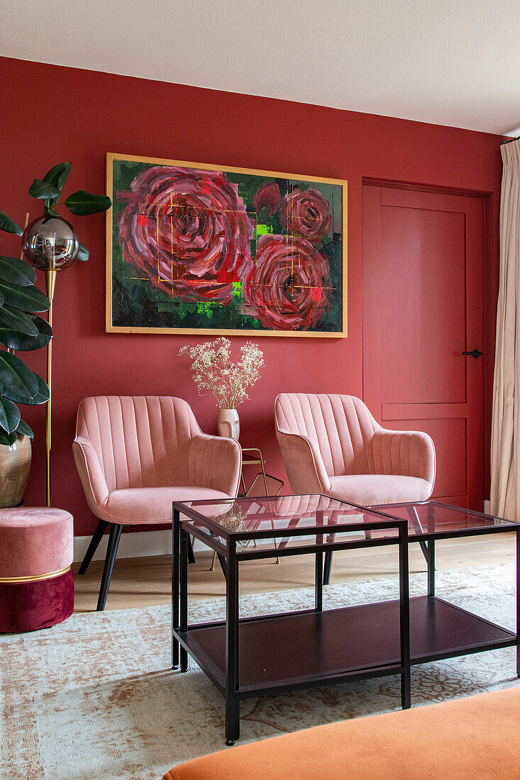 Living room with red walls, pink armchairs and rose picture