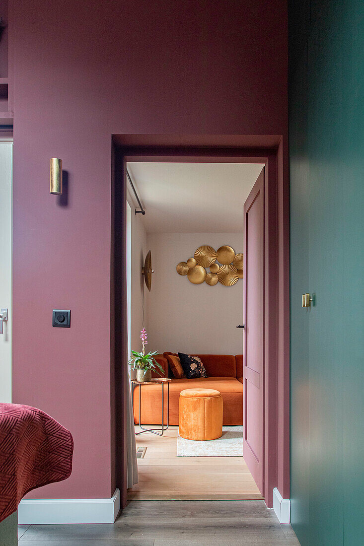 View of the living room with orange sofa and golden wall decoration