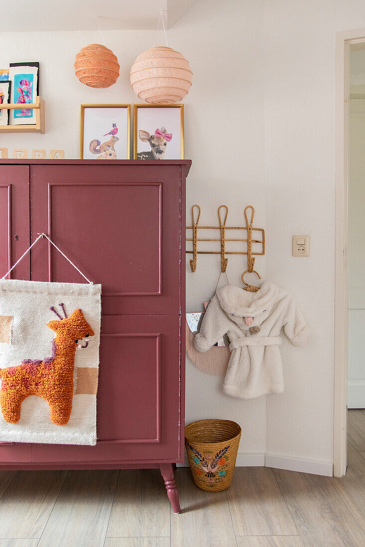 Kinderzimmer mit rotem Schrank und Wanddekoration