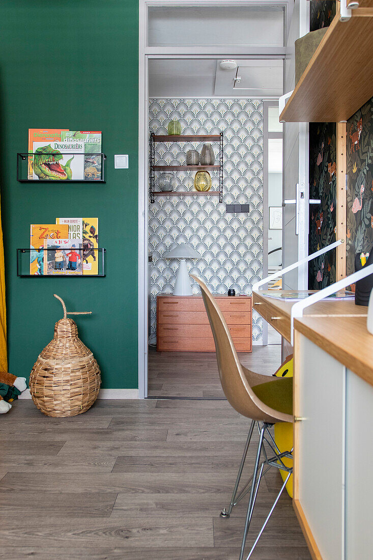 Work area in the children's room with green wall colour and open wall shelves