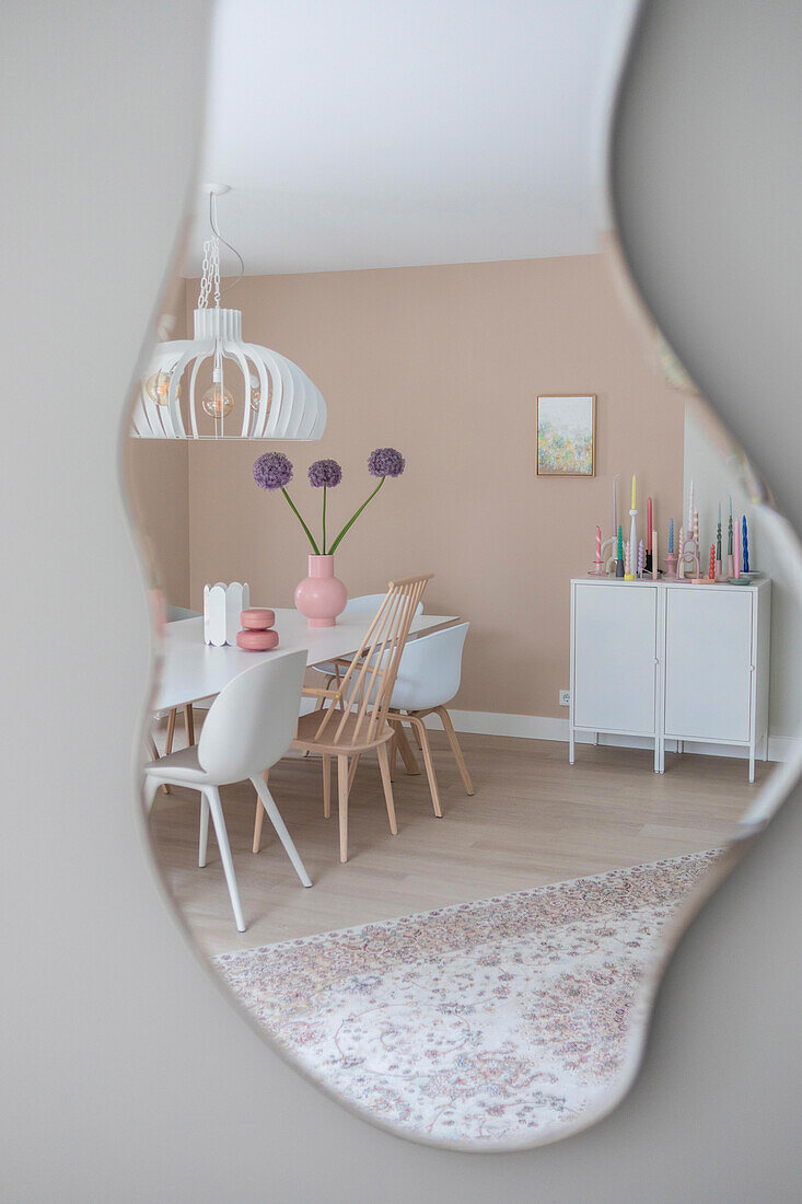 Mirror image of a dining room in white and pastel colors