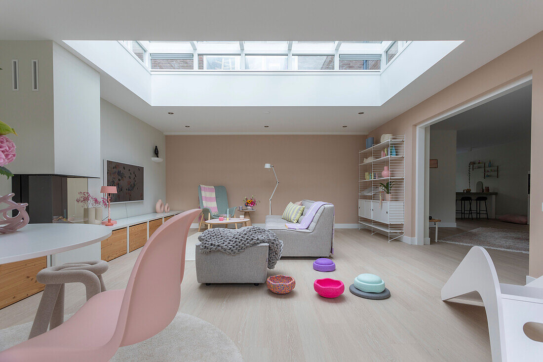 Bright living room with skylight, pastel-colored decor and grey sofa