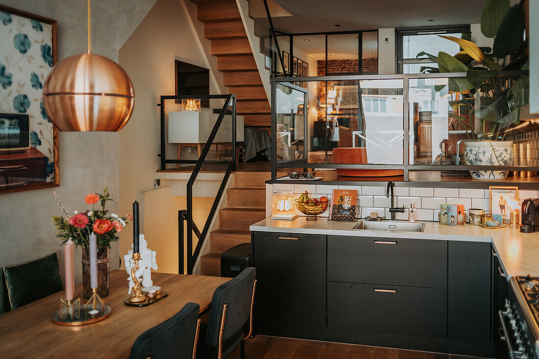 Open-plan dining room with modern kitchen and wooden staircase