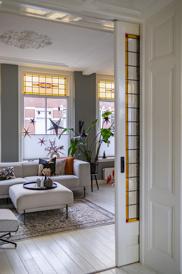 Living room with light sofa, grey wall paint and stucco ceiling