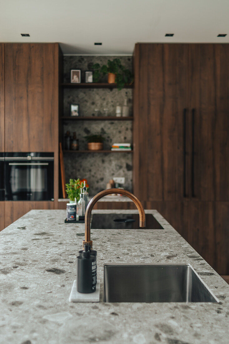 Modern kitchen with natural stone worktop and copper faucet