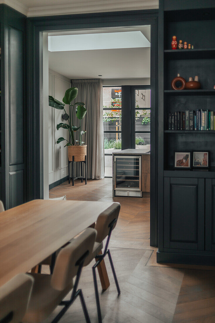 Dining room with wooden chairs and view of modern kitchen