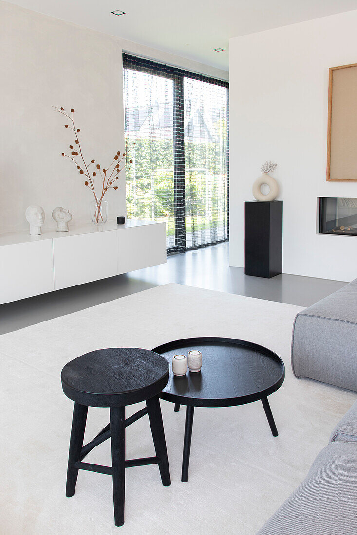 Minimalist living room with black side tables and abstract art