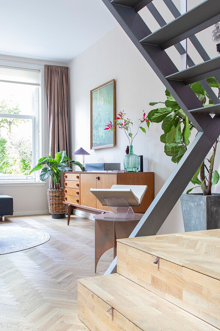 Bright living room with staircase and mid-century sideboard