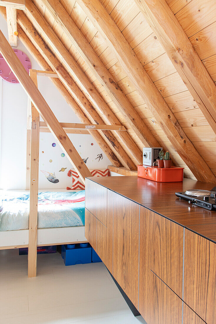 Bed and sideboard in room with sloping ceiling