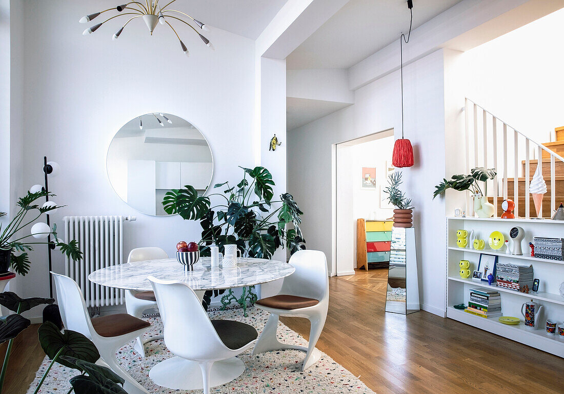 Round marble dining room table with white chairs and retro elements