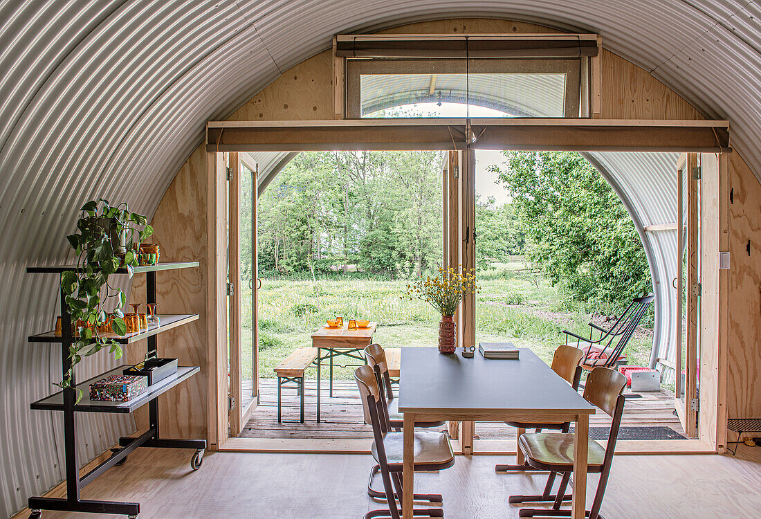 Essbereich im Tiny House mit gewölbtem Metalldach und hellem Holzboden