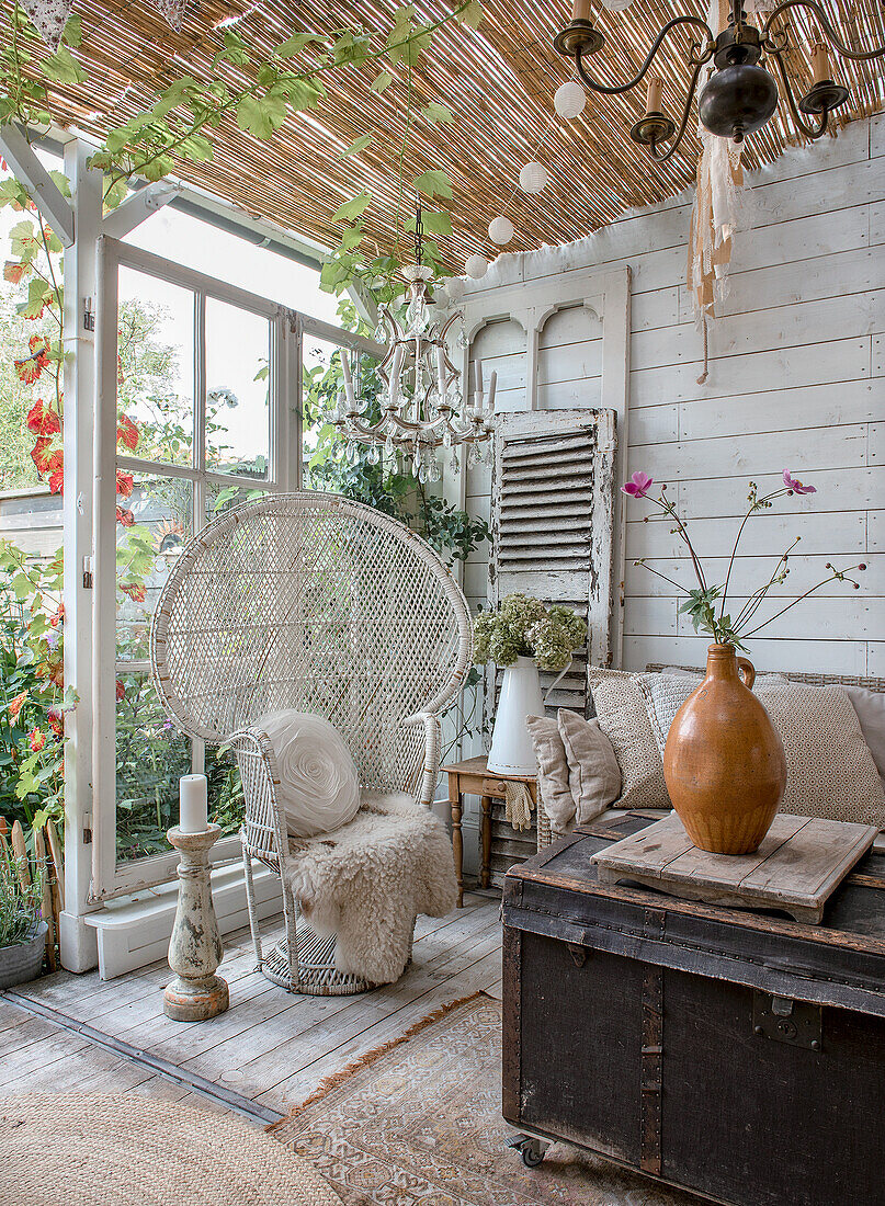 Covered terrace with rattan furniture and shabby chic decor