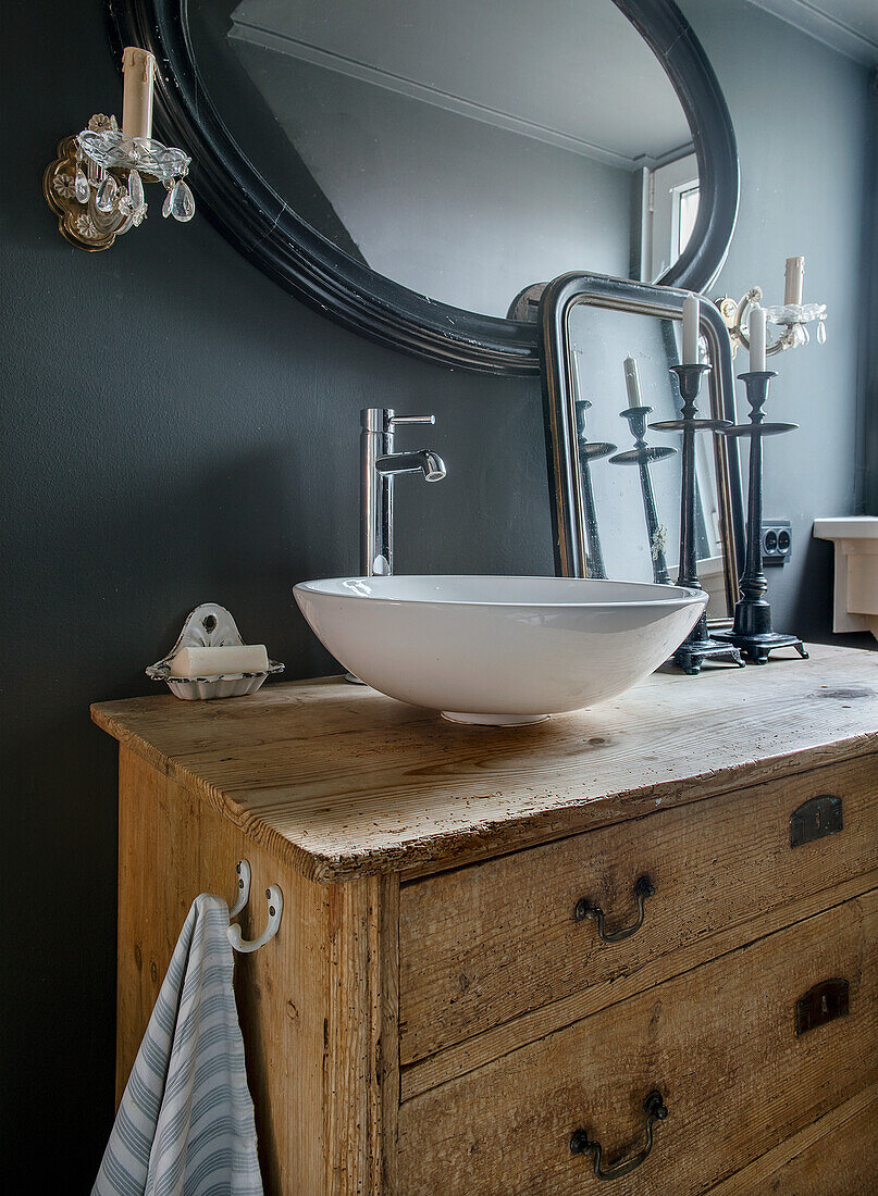 Rustic wooden chest of drawers as a washstand in the bathroom