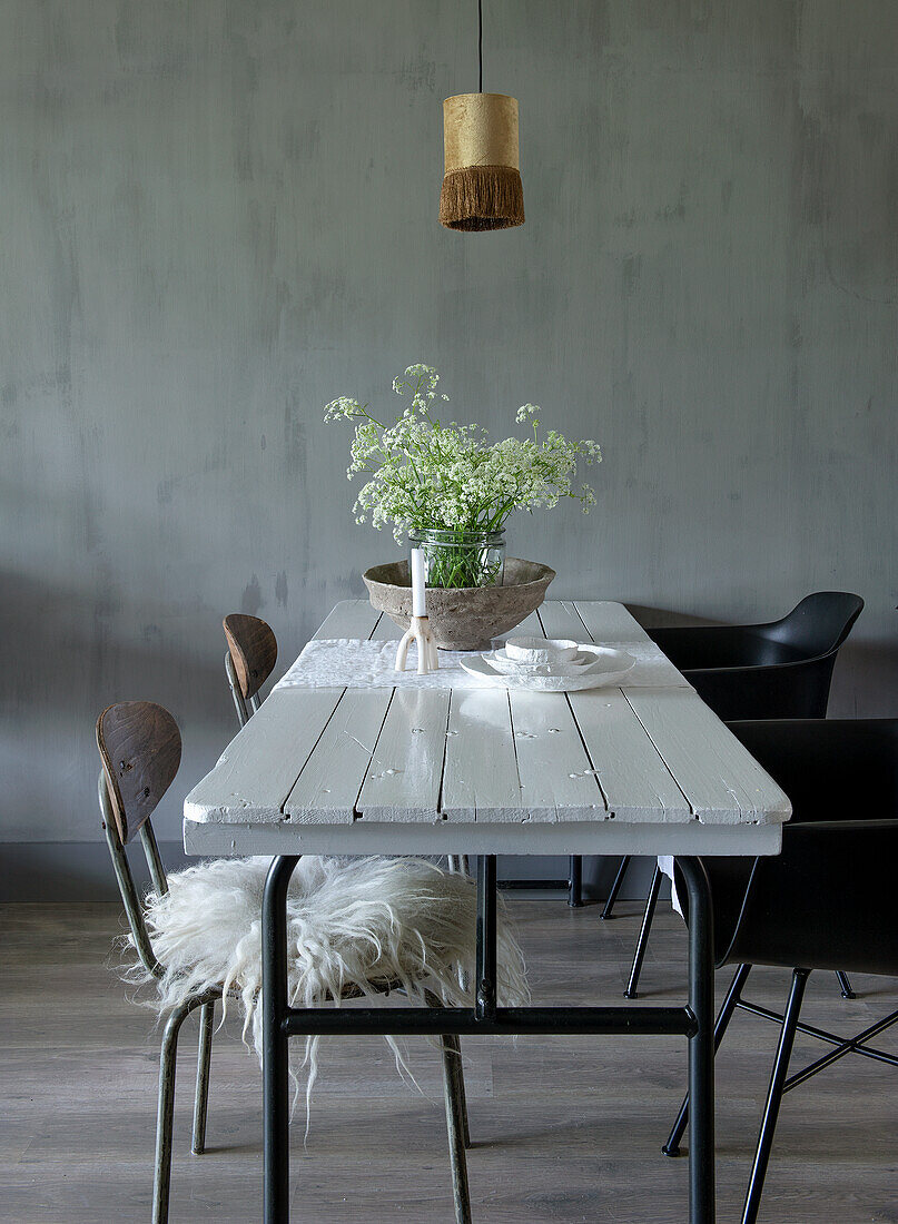 White wooden table with wildflowers in a minimalist dining room