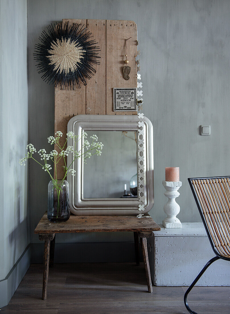 Holztisch mit Spiegel und Blumenvase, Holzbretter als Wanddeko