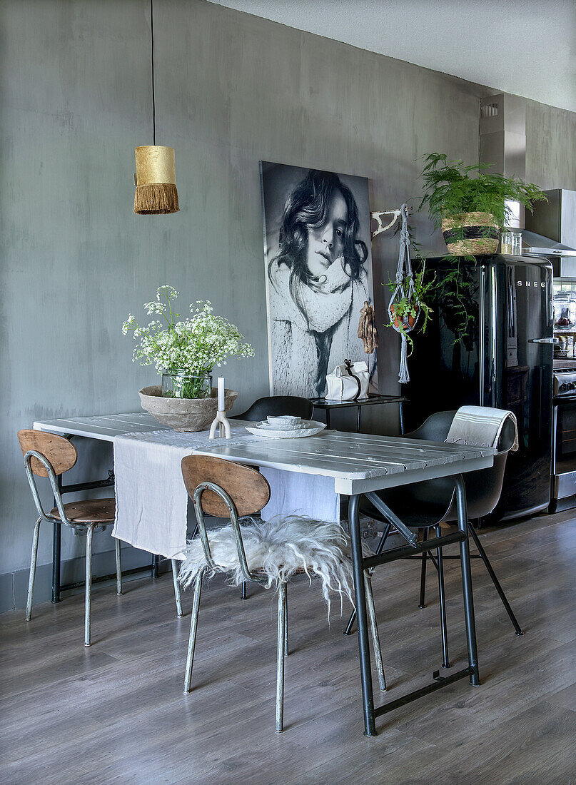 Dining table with chairs and large black and white picture in the open-plan living area