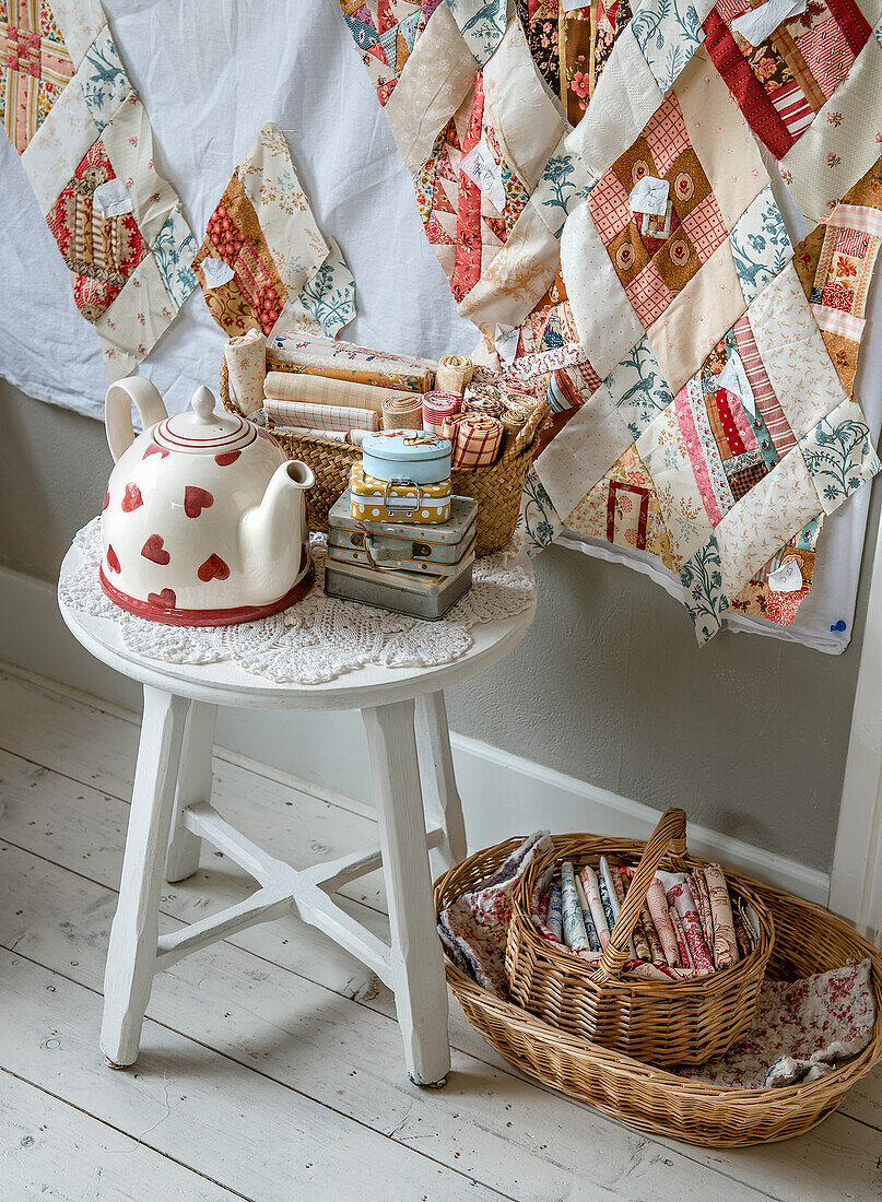 Corner with patchwork blanket, teapot and sewing utensils