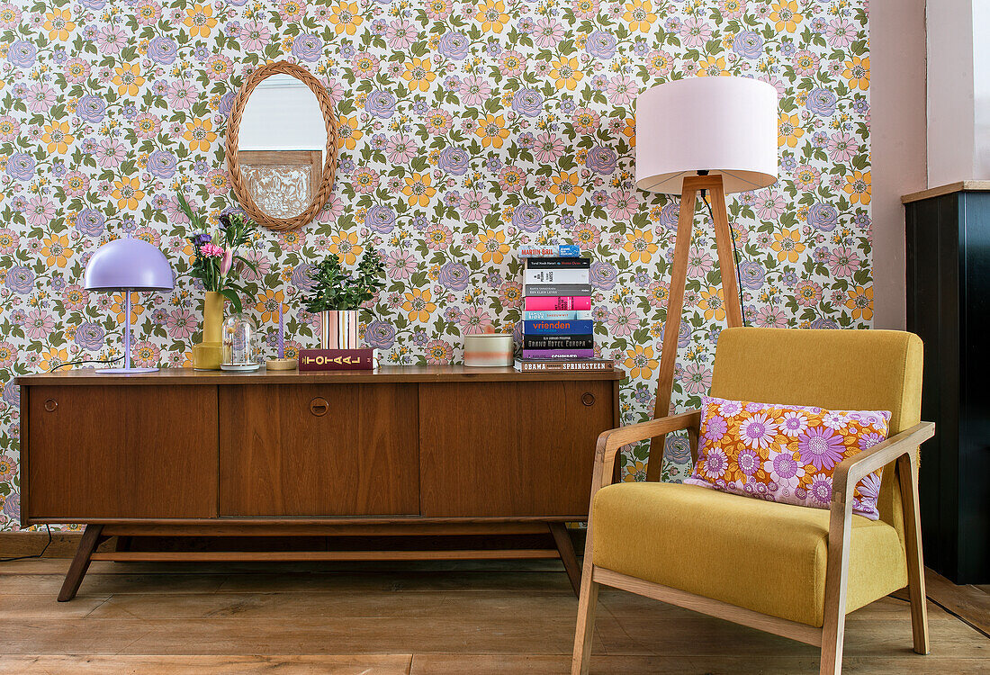 Retro living room with floral pattern wallpaper, armchair and sideboard