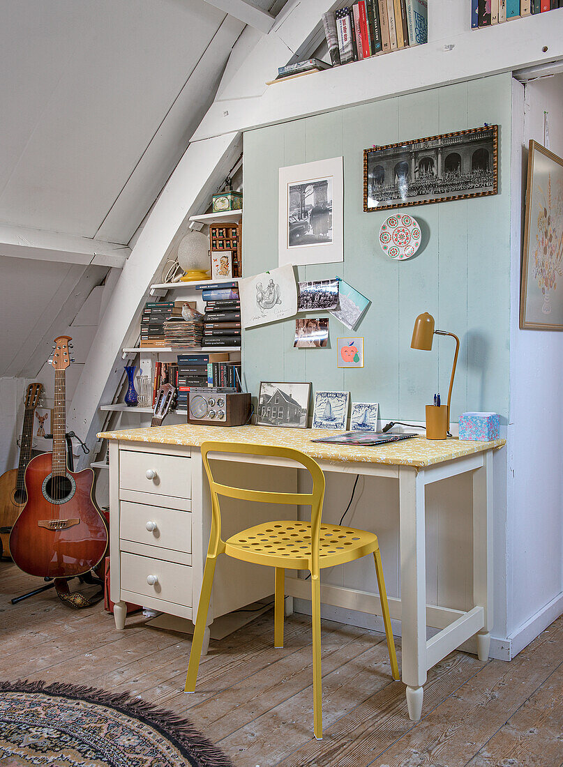 Workplace in the attic with yellow chair and guitar