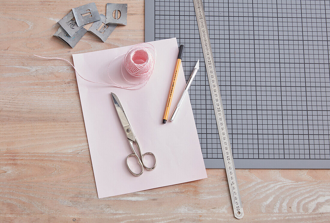 DIY crafting utensils: cutting mat, scissors, ruler, paper, pens, thread