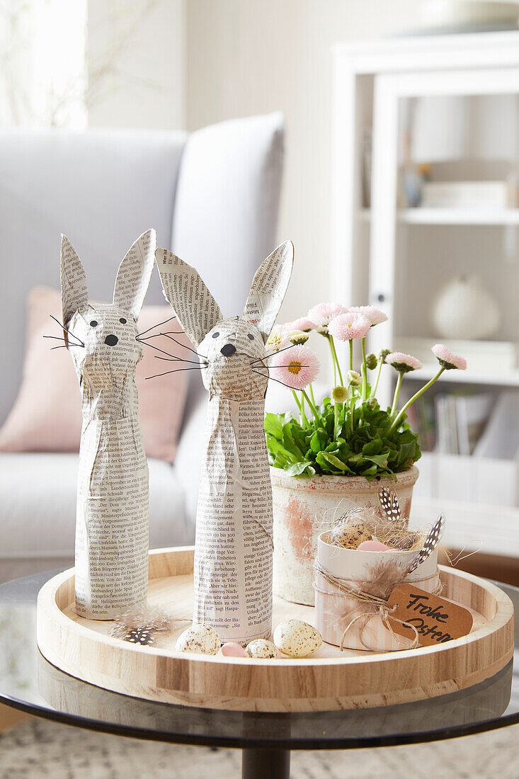 Wooden tray with DIY bunny made from newspaper and spring flowers in the living room