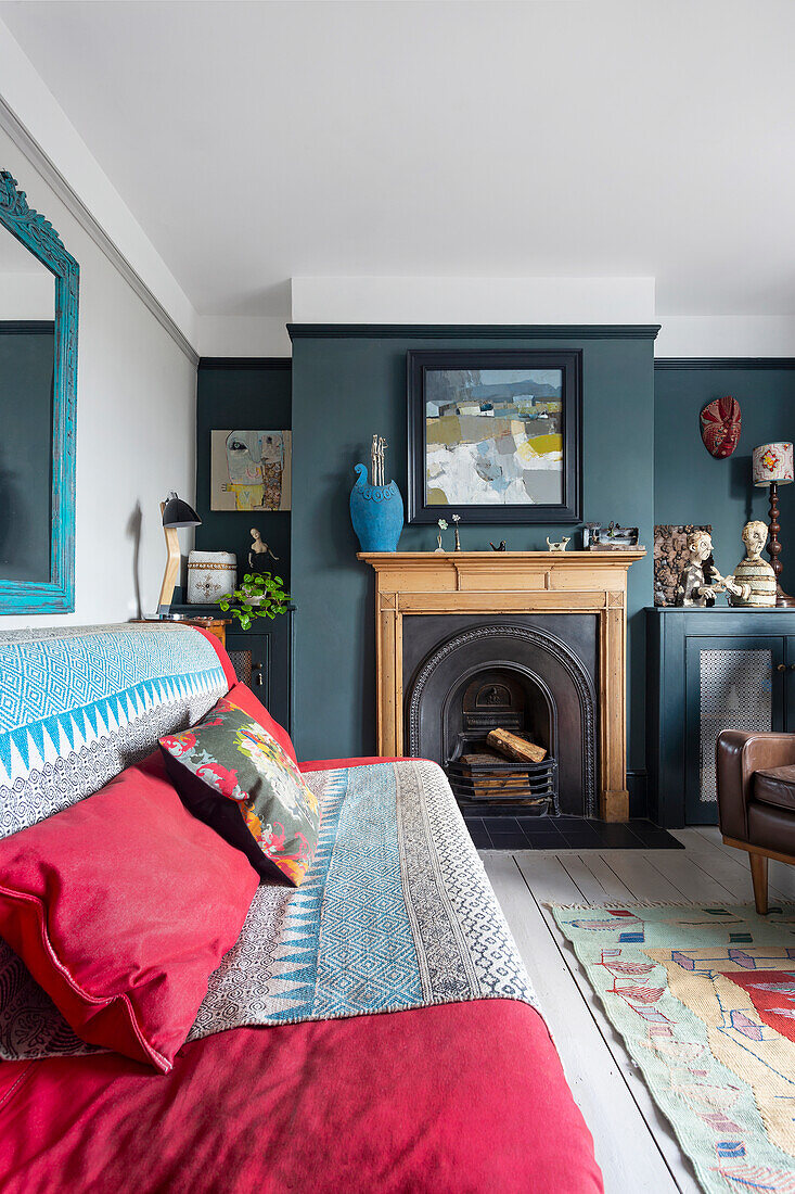 Living room with fireplace, dark blue walls and red sofa