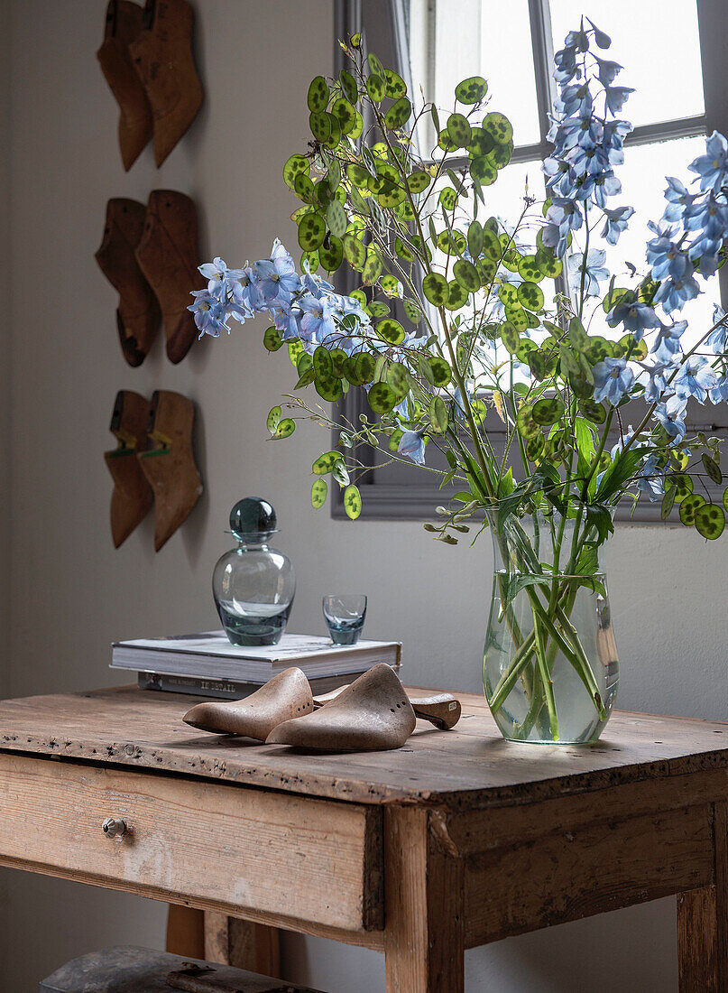 Bouquet of flowers and antique shoe trees on a rustic wooden table