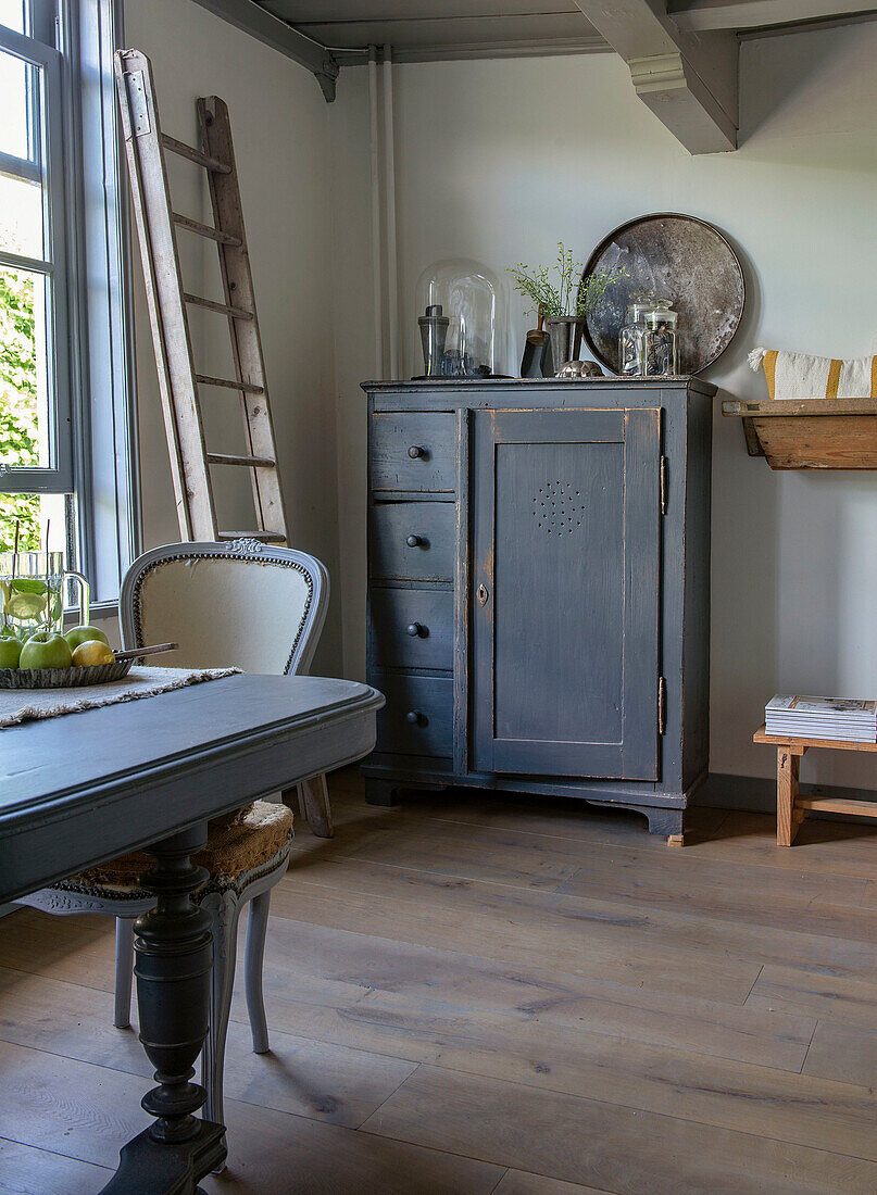 Antique grey wooden cabinet and ladder in rustic dining room