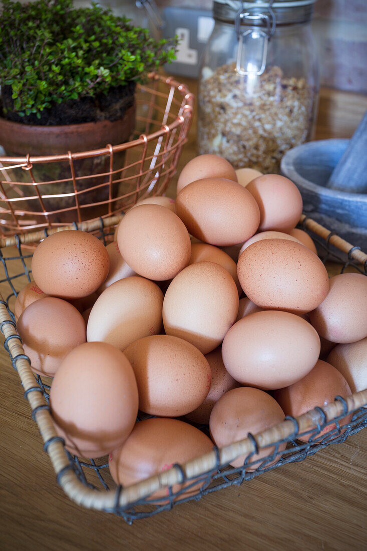 Frische Eier in Drahtkorb in der Küche