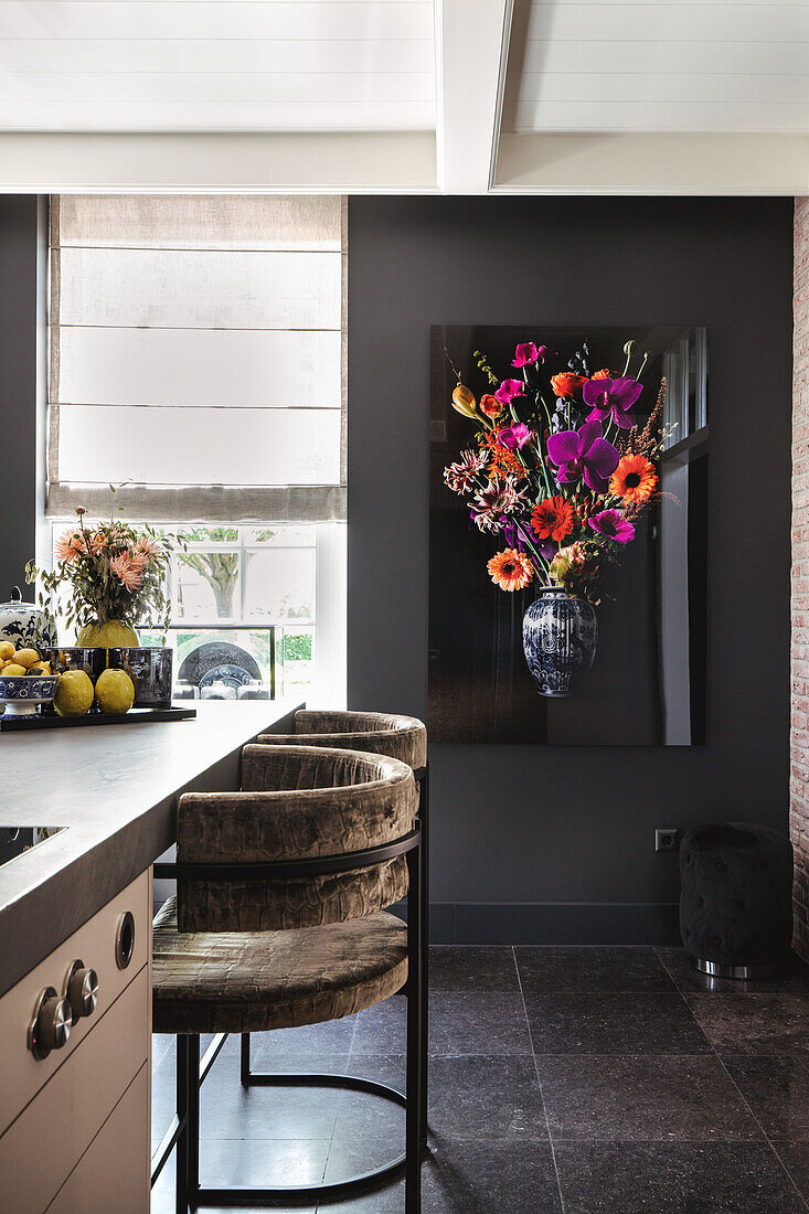 Modern kitchen with bar stools, dark wall colour and flower painting on the wall