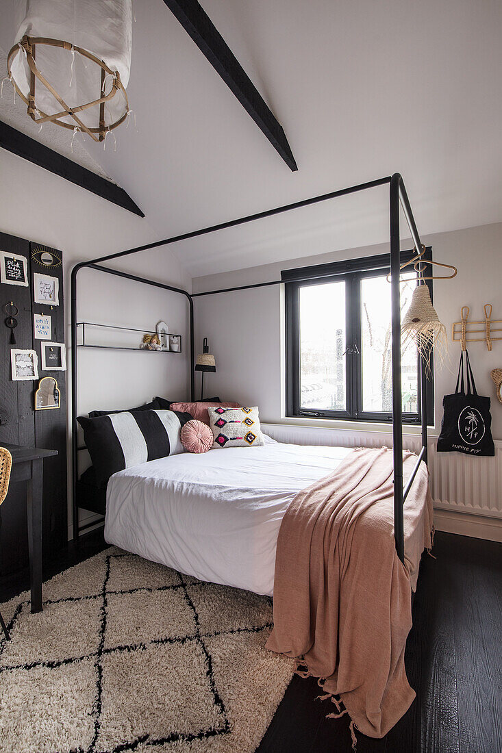 Bedroom with black and white colour scheme and metal four-poster bed