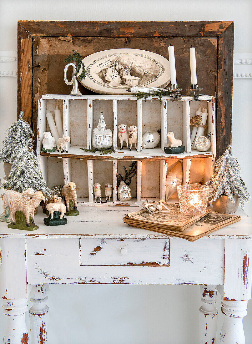 Setzkasten und Tisch mit Schaffiguren und Weihnachtsschmuck auf Tisch in Shabby-Style
