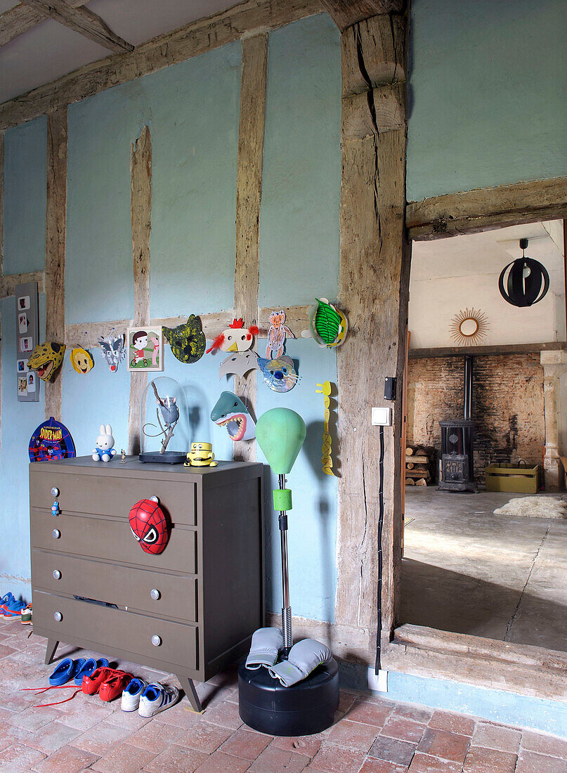 Kommode in ländlichem Kinderzimmer mit blauer Wand und Holzbalken