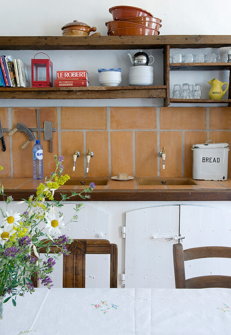 Open shelves above kitchen counters in country-style kitchen