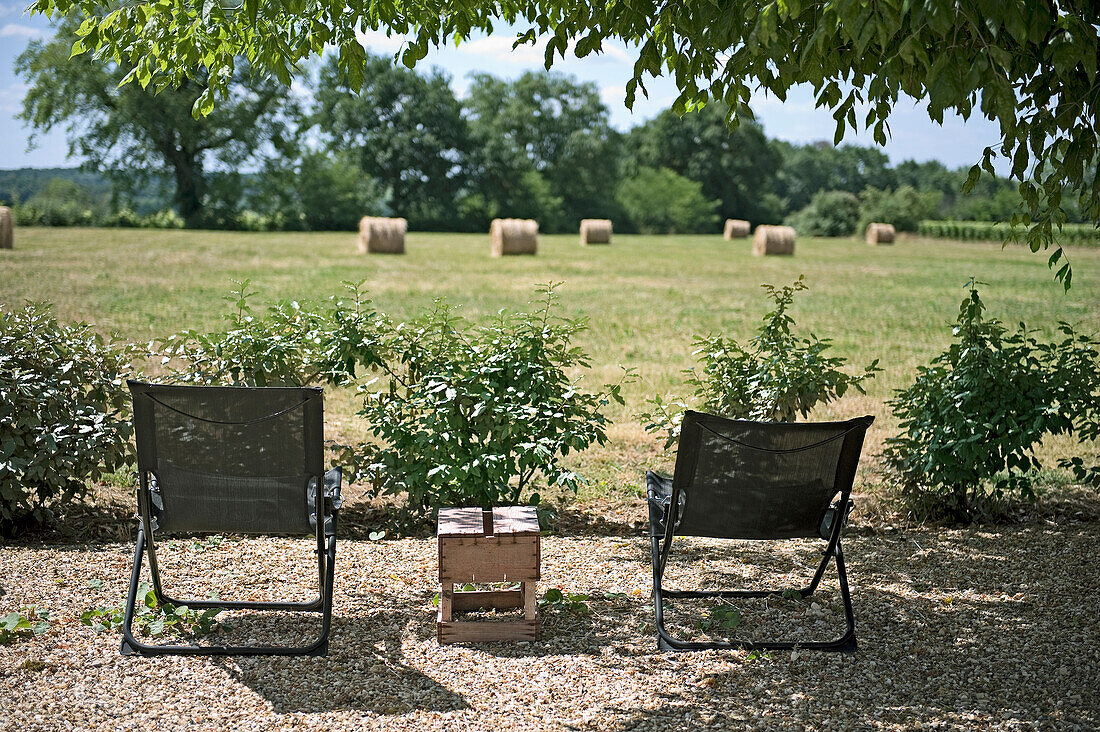 Stühle auf Kiesboden mit Landschaftsblick