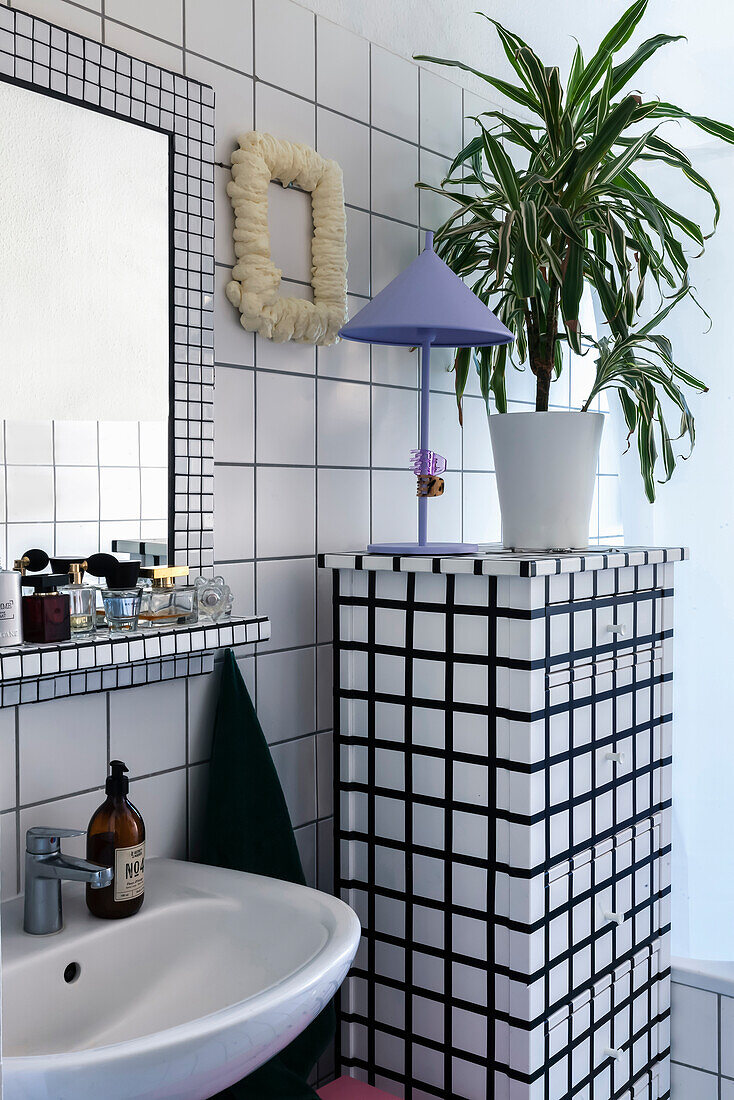 Bathroom with white tiled paneling and mosaic mirror