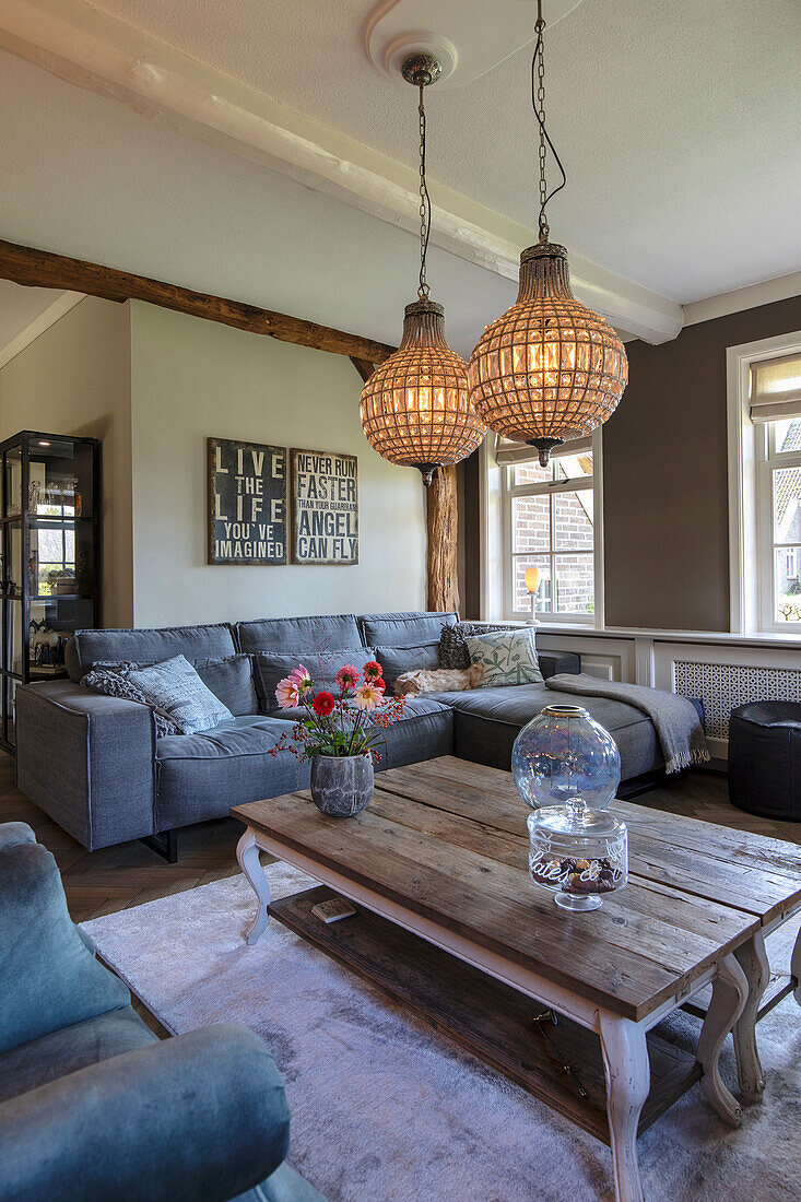 Living room with corner sofa, glass pendant lights and wooden coffee table