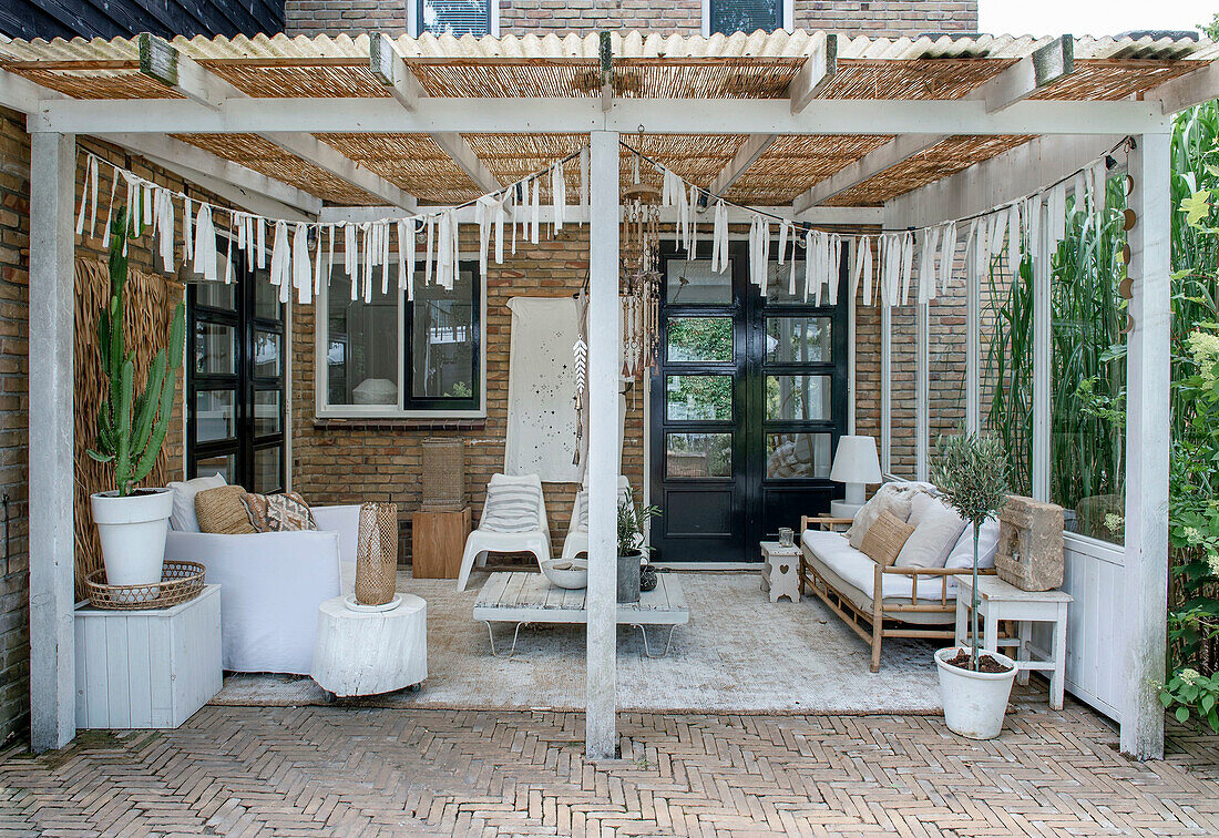 Covered terrace with sofas, wooden table and garland