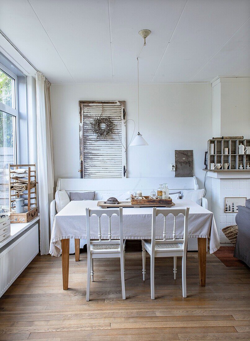 Dining table, bench, white chairs and vintage decorations