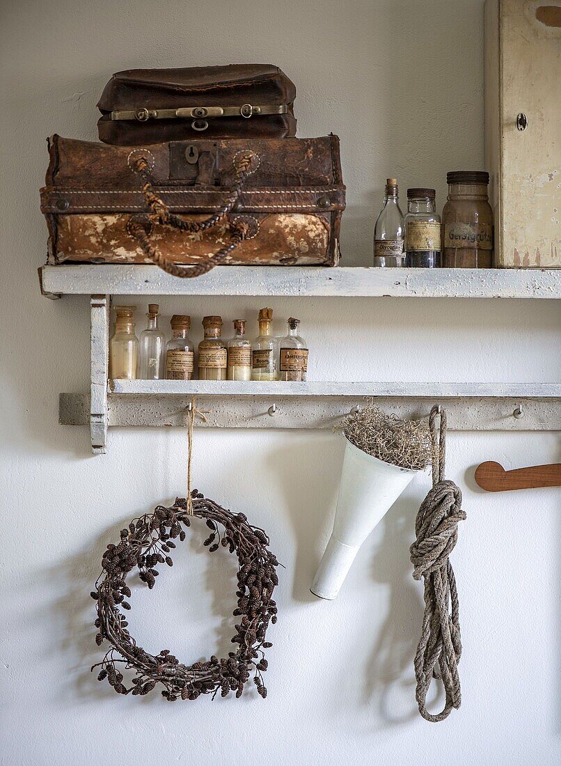 Vintage shelf with antique suitcase, bottles and decorations