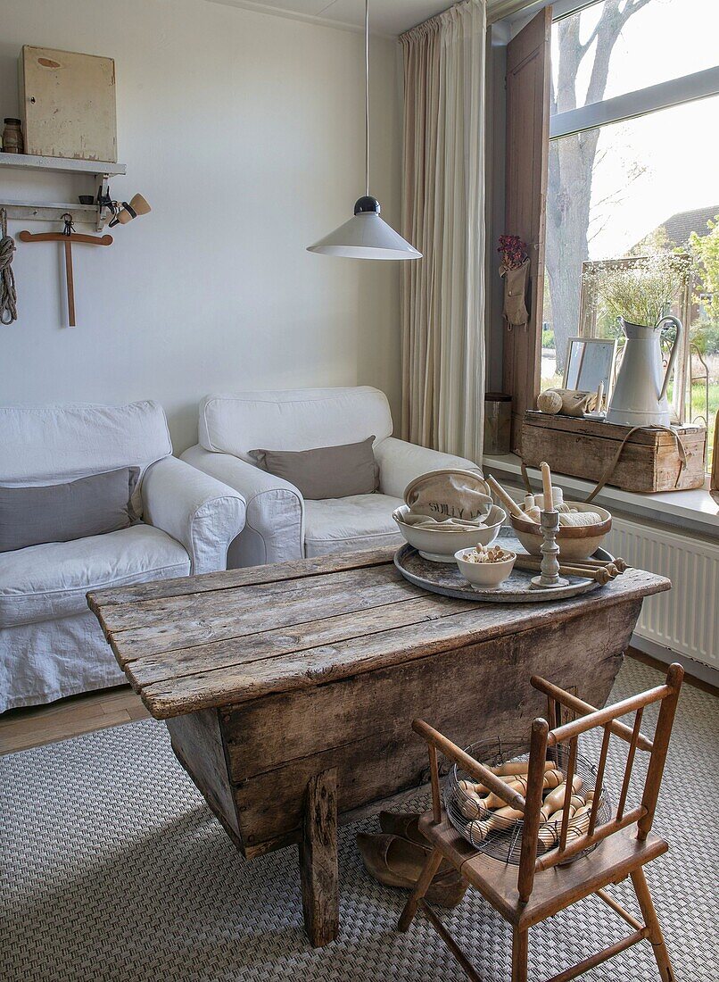 Country-style living room with rustic wooden table and white sofa