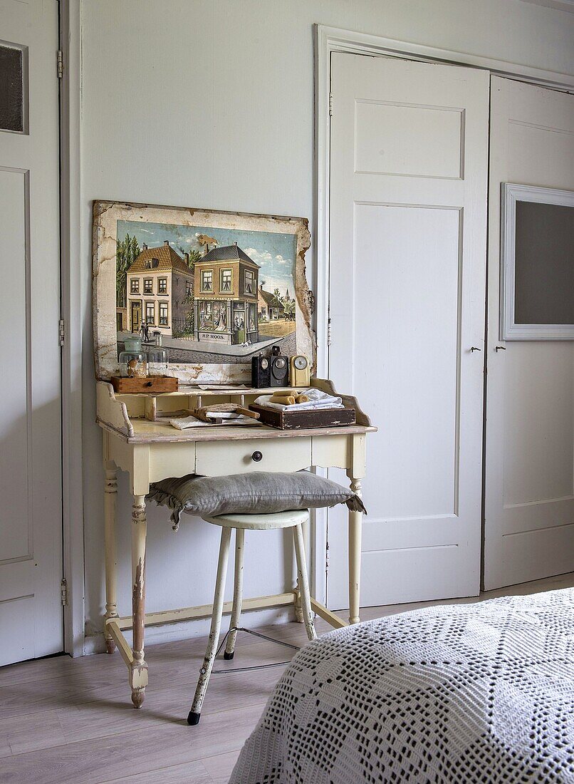 Antique table with stool and decorative picture in the bedroom