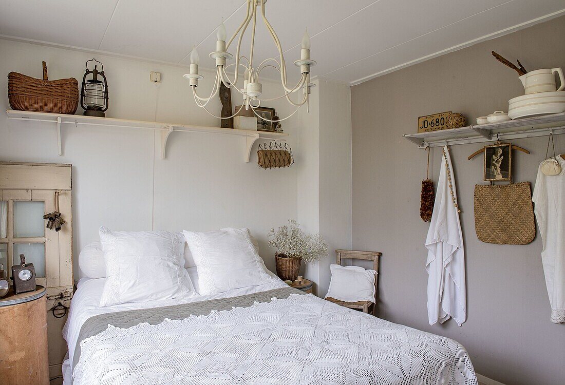 Country-style bedroom with white bed linen and wooden furniture