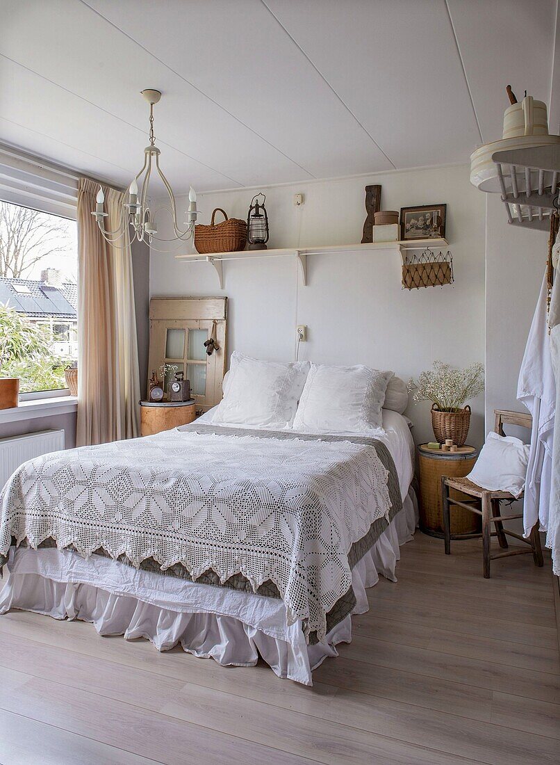 Schlafzimmer im Landhausstil mit gehäkeltem Bettüberwurf und Holzaccessoires