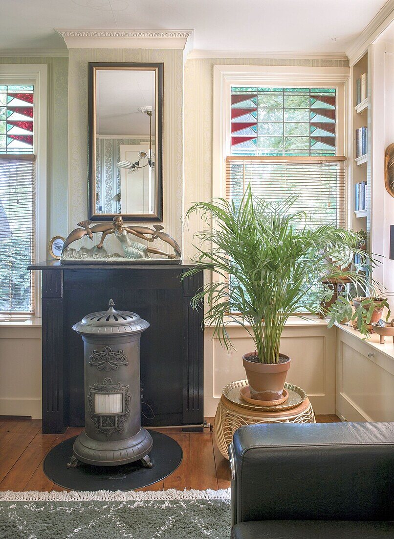 Room with antique stove, plant and colorful stained glass windows