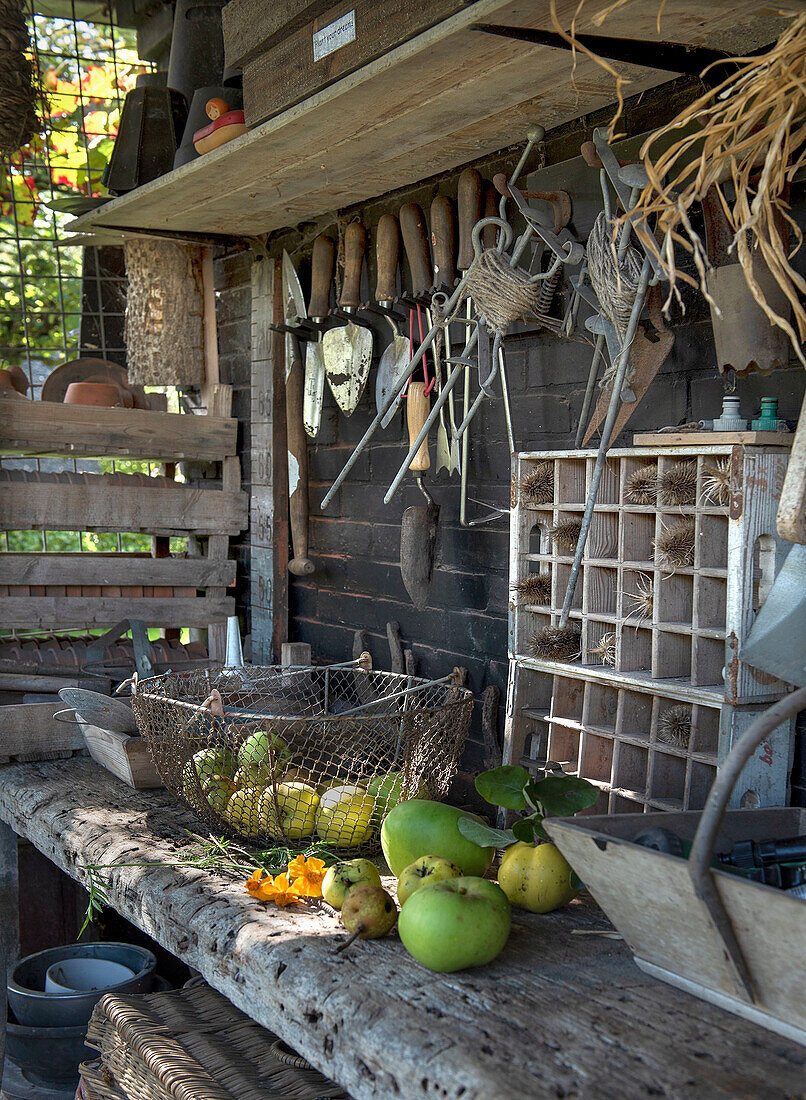 Gartentisch mit Werkzeugwand und Obstkorb