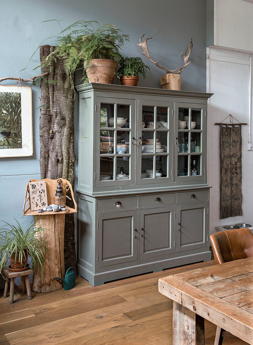 Dining room with grey display cabinet and rustic wooden furniture