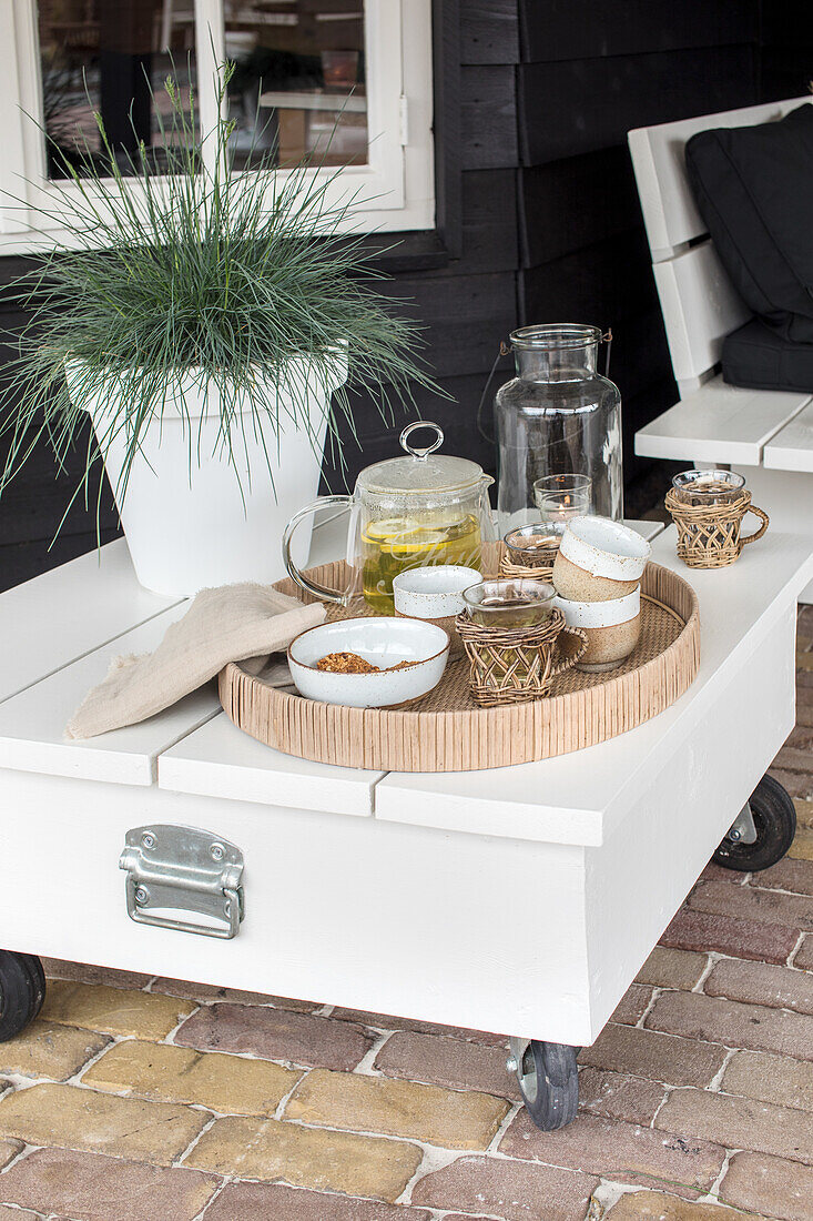 White patio table with drinks and snacks on tray