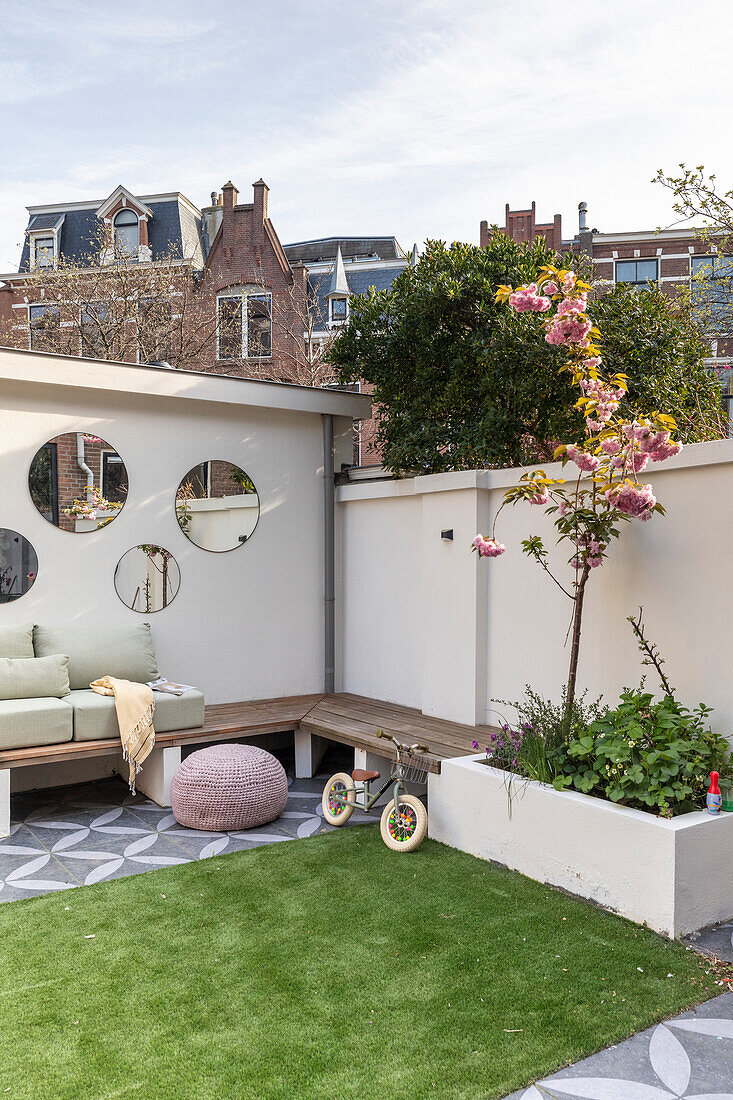 Seating area on modern city terrace with artificial turf