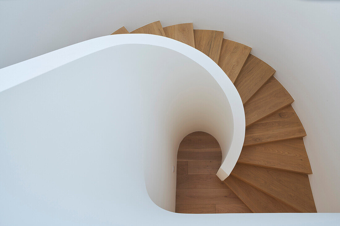 Staircase with wooden steps and white walls